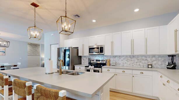 A modern kitchen with white cabinetry, stainless steel appliances, and a central island with bar stools. - Outdoor Oasis! Group-Friendly Miami Getaway (Miami)