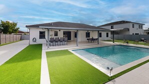 A modern house with a swimming pool, covered patio, and neatly trimmed lawn. - Outdoor Oasis! Group-Friendly Miami Getaway (Miami)