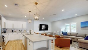 A modern kitchen with white cabinets, a central island, and pendant lighting. - Outdoor Oasis! Group-Friendly Miami Getaway (Miami)