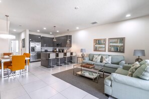 A modern living room with a sofa, coffee table, and dining area. - 1521 Dream (Clermont)
