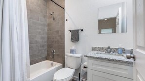 Et badeværelse med badekar, toilet og håndvask.