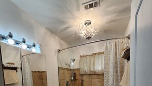 Ein Badezimmer mit Dusche, Toilette, Waschbecken und einer Duschkabine aus Glas.