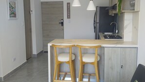 A modern kitchen with a wooden island, two pendant lights, and a built-in stove. - Apartment in Cartagena Torices near the sea of Marbella (Cartagena de Indias)