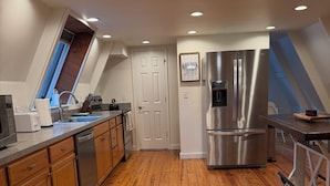 A modern kitchen with wooden cabinets, stainless steel appliances, and a skylight. - Cozy A frame cabin in quaint Front Royal. Dog friendly (Front Royal)