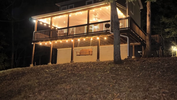 A two-story house with a balcony, string lights, and a swing. - Cozy A frame cabin in quaint Front Royal. Dog friendly (Front Royal)