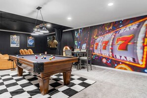 A pool table with balls, a bar area, and a wall with a slot machine mural. - KnoxHaven | 5 Min UT•Hot Tub•Firepit•Theater•Games (Knoxville)