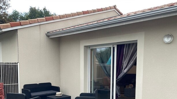 A covered outdoor seating area with a sofa set and a table, a sliding glass door, and a metal gate. - House near Bordeaux, 3 minutes from the ARENA (Bouliac)
