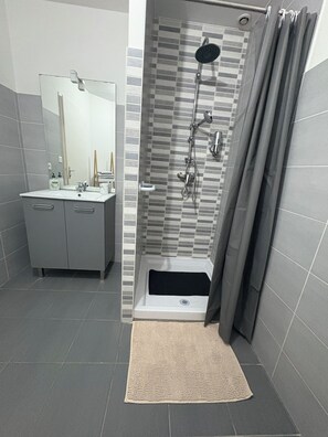 Chuveiro, secador de cabelo, toalhas de banho, shampoo