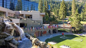 A hotel with a waterfall, a pool, and a flag display.
