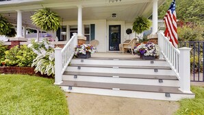 A house with a porch, steps, and an American flag.