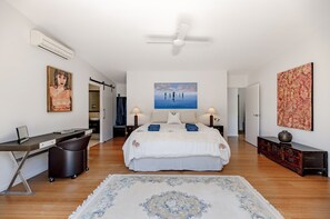 Une chambre à coucher moderne, avec un lit, des tables de chevet, un bureau et une chaise.