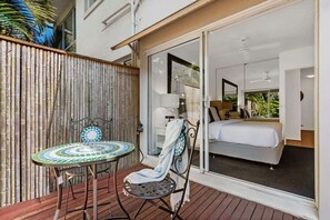 Ein Zimmer mit einem Bett, einem Tisch und einem Stuhl auf einer Holzterrasse.