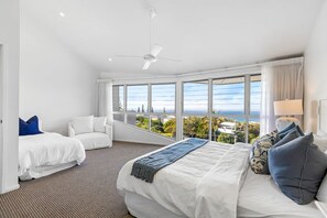 A hotel room with a large bed, two white sofas, a ceiling fan, and a view of the ocean. - 8 Andari Sunshine Luxury 1min to Beach (Sunshine Beach)