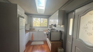 A compact kitchen with a skylight, wooden flooring, and a small trash bin. - Quiet Rural Retreat - Kimbriki (Mount George)