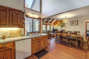 A spacious kitchen with wooden cabinets, a dishwasher, and a large window. - 1/4 Mi to Golf & Skiing! Sugar Mountain Getaway (Sugar Mountain)