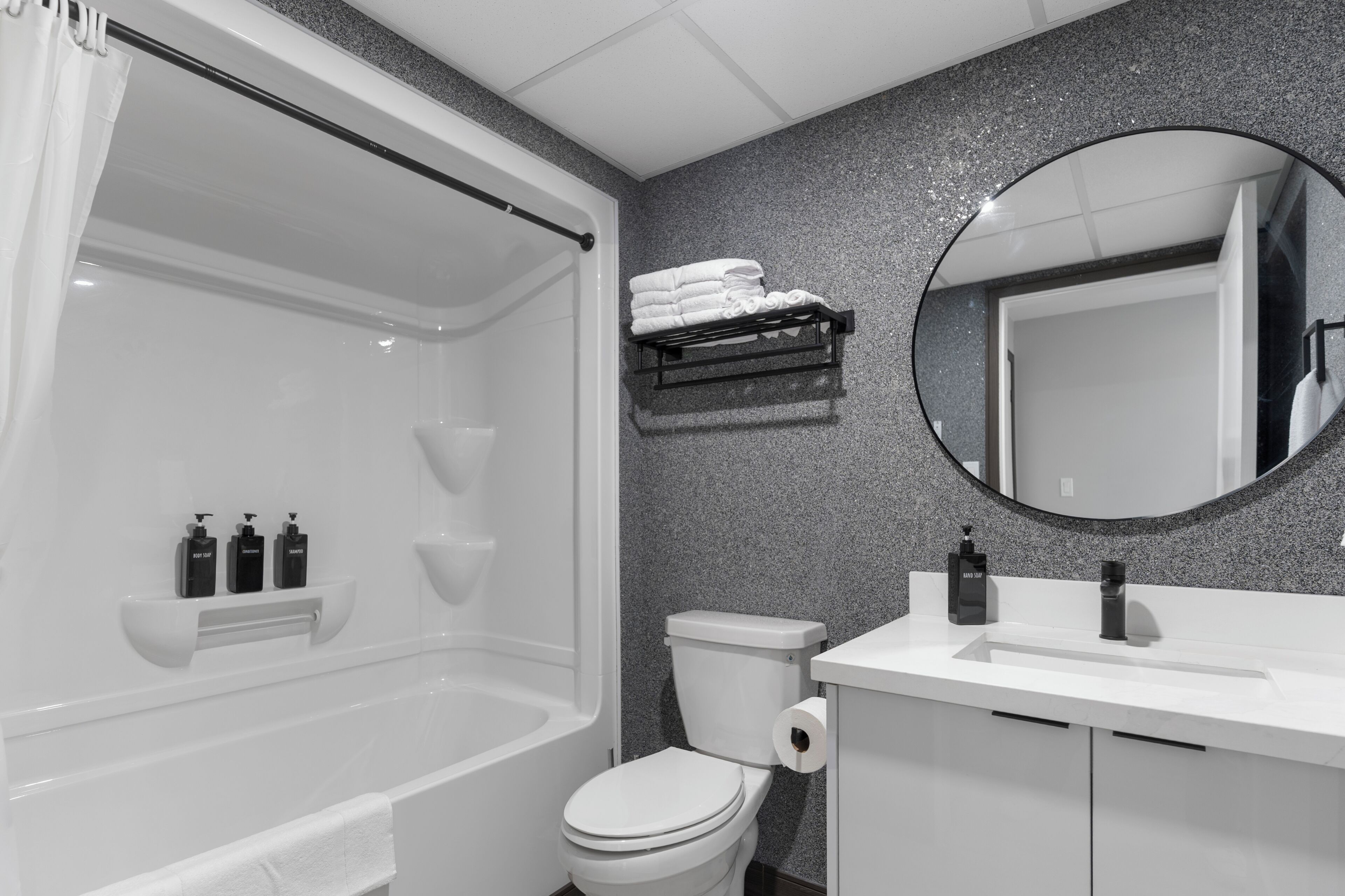 A modern bathroom with a bathtub, toilet, and sink.