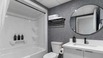 A modern bathroom with a bathtub, toilet, and sink.