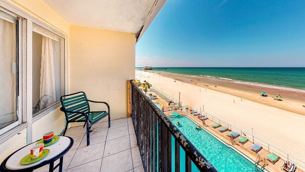 A balcony with a view of a beach and a swimming pool. - Private Balcony, Oceanfront Pool, Walk to Boardwalk & Pier (Daytona Beach)