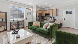 A modern kitchen with a refrigerator, microwave, and stove.