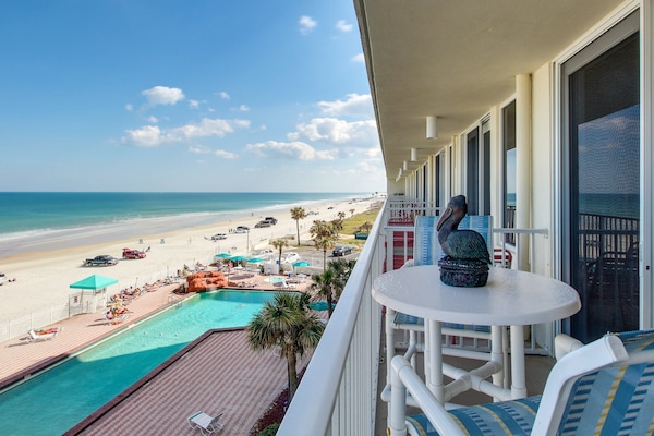 Stunning oceanfront balcony view overlooking the pool and sandy shoreline. Enjoy your beach stay with panoramic ocean views, sea breezes, and a front-row seat to beach life just steps below.