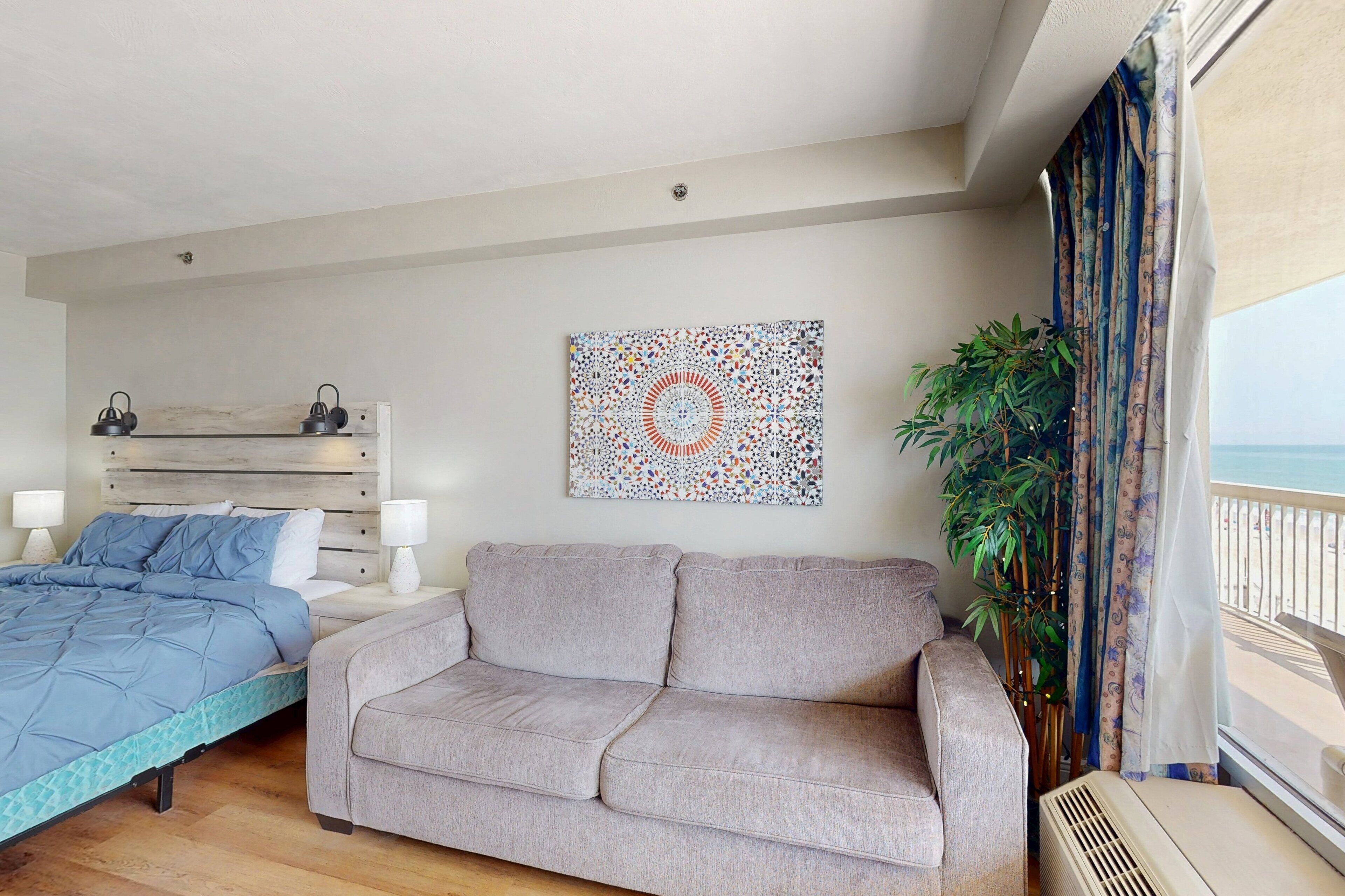 Relax in this bright beach stay studio featuring a plush sofa, oceanview windows, and cozy décor. A perfect spot to unwind after sandy beach days and enjoy calming coastal breezes.