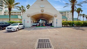 A hotel entrance with a prominent DBR sign, paved driveway, parked cars, and palm trees. - Oceanfront Studio with Balcony Views & Walkable to Daytona Attractions (Daytona Beach)