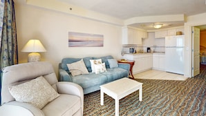 A living room with a sofa, a coffee table, and a patterned rug. - Oceanfront Studio w/ Balcony & Resort Perks Near Boardwalk (Daytona Beach)