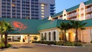 A hotel with multiple buildings, a green roof, and a palm tree-lined entrance. - Chic Oceanfront Studio with Balcony, Pool & Direct Beach Access (Daytona Beach)