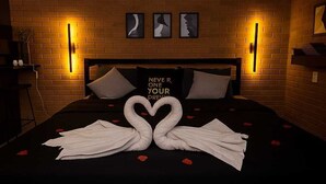 A hotel room with a brick wall, a bed with a black bedspread, and a pillow with the text "NEVER R YOUR PREVAIL". - Cozy House "exclusively for Couples" Pet Friendly (Bragança Paulista)
