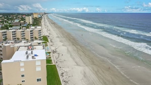 Un hotel frente al mar con varios pisos, vistas a la playa y una extensa franja costera.