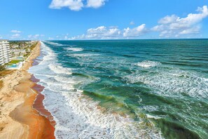 Une plage avec un hôtel situé le long du rivage.