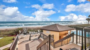Een strandhuis met zwembad, terras en uitzicht op de oceaan.