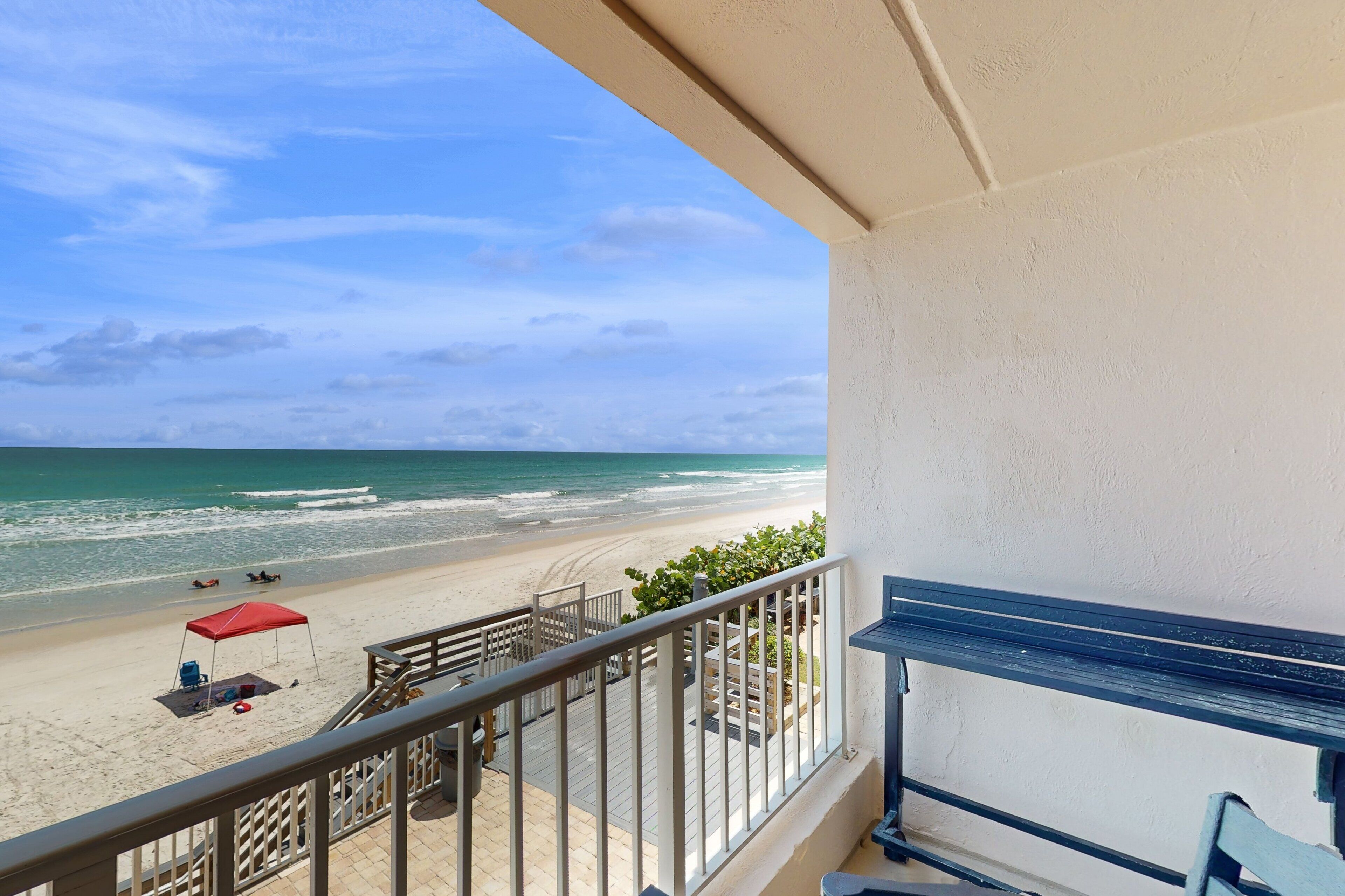 Ein Balkon mit Blick auf Strand und Meer.