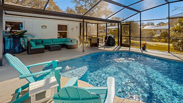 Un espace piscine doté d’une enceinte en verre, de sièges et offrant une vue sur l’extérieur.