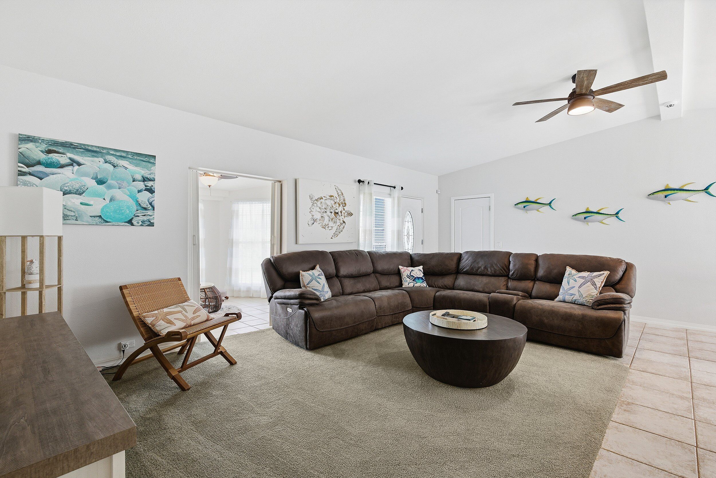 Relax after a day at the beach in this airy coastal living room featuring plush seating, beach-inspired décor, and an open layout. Perfect for unwinding, gathering, and enjoying a comfortable beach stay with family and friends.