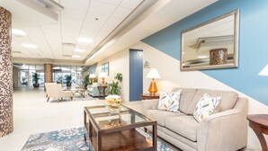 A spacious lobby with a sofa, coffee table, and decorative lamps. - Oceanfront Studio with Balcony, Resort Pools & Walkable Fun (Daytona Beach)