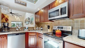 Una cocina moderna con armarios de madera, electrodomésticos de acero inoxidable y encimera de granito.