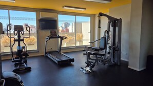 A gym with a treadmill, weight machines, and a TV on the wall. - Excellent apartment in building with amenities. In front of Abasto Shopping Mall (Buenos Aires)