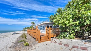 A beachfront property with a wooden deck, a garage, and a view of the ocean. - Gulf View Escape on the Beach at Resort with Pool, Kayaks, and More! (Englewood)