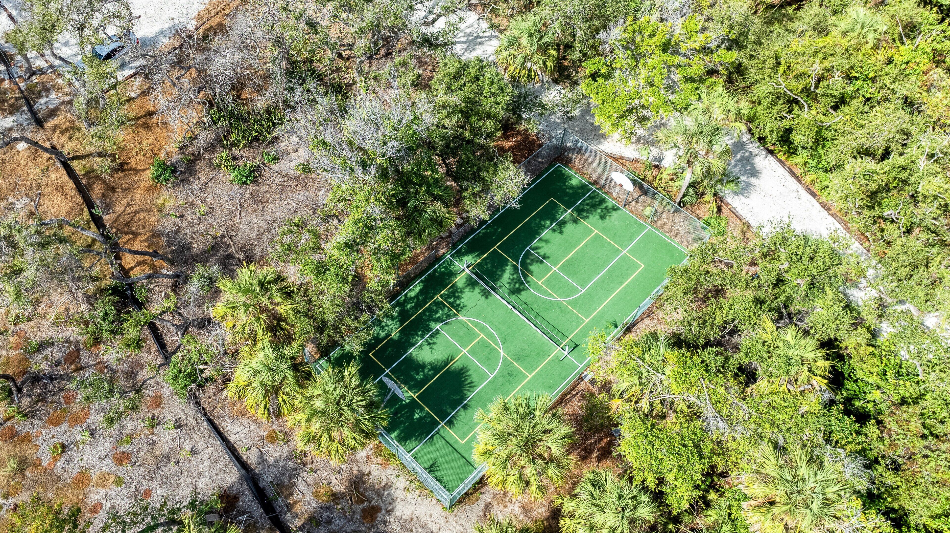 The court lies in a hammock of oaks and palms, waiting for your first serve.