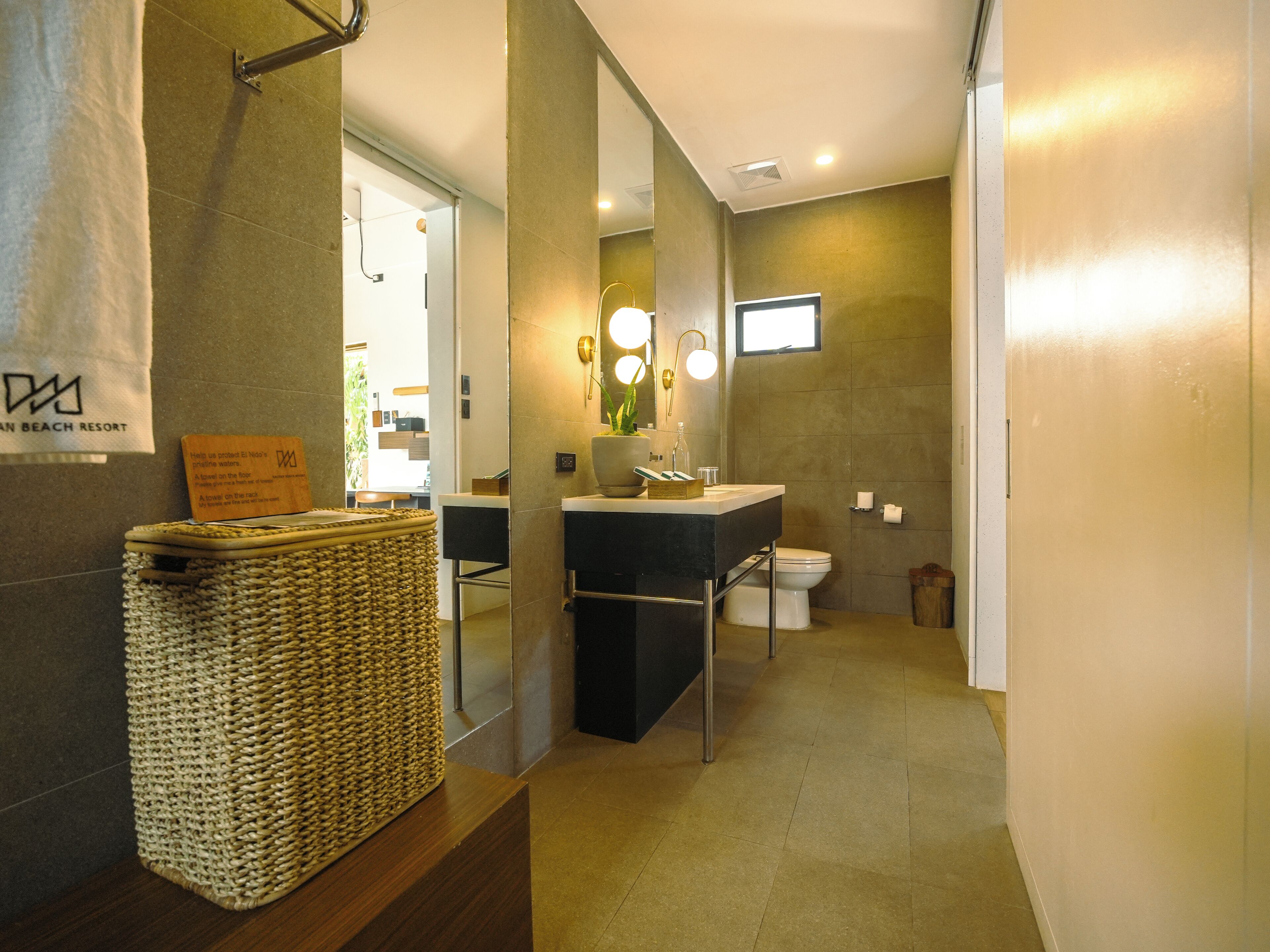 Un baño moderno con un espejo grande, un lavabo y un inodoro.