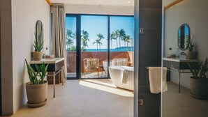 Un baño moderno con bañera, espejo y planta en maceta.