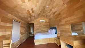 A wooden-paneled room with a bed, bedside table, and a mirror. -  Beach  just a few steps away, offering easy access to the island’s attractions. (Preah Sihanouk)