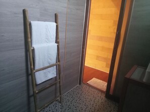 A bathroom with a wooden ladder, a white towel, and a patterned floor. -  Beach  just a few steps away, offering easy access to the island’s attractions. (Preah Sihanouk)