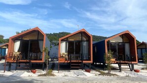 Three wooden cabins with large windows and a clear sky. -  Beach  just a few steps away, offering easy access to the island’s attractions. (Preah Sihanouk)