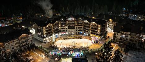 A large, multi-story hotel with a central courtyard, surrounded by snow-covered ground and trees.