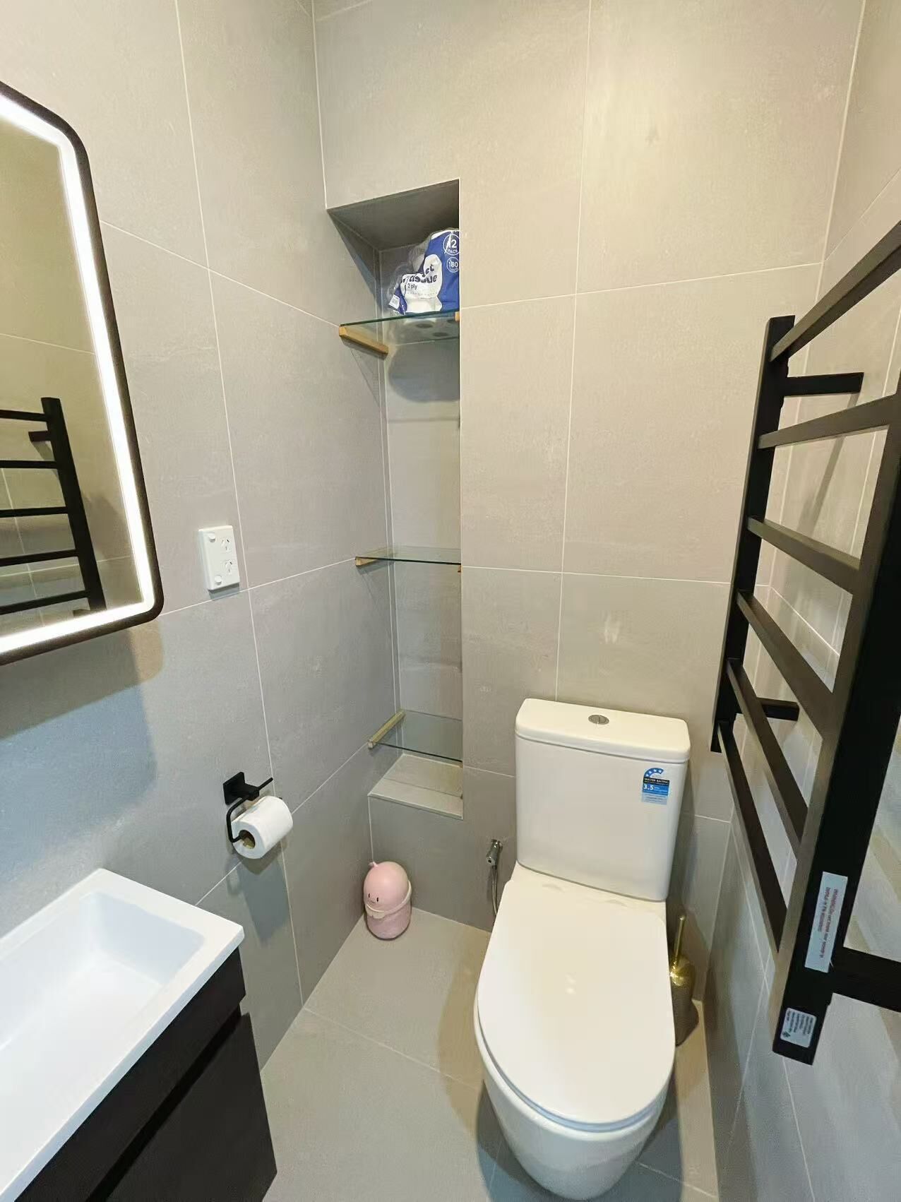 A small bathroom with a toilet, a sink, and a shower.