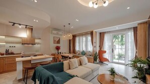 A modern living room with a sofa, coffee table, and dining area. - 3 bedroom Villa Venus House Phan Thiet (Phan Thiet)
