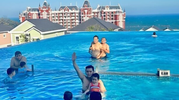 A swimming pool with a view of a large, ornate building in the background. - 3 bedroom Villa Venus House Phan Thiet (Phan Thiet)