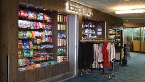 Ein Geschäft mit Verkaufsregalen voller Snacks und einem Kleiderständer.
